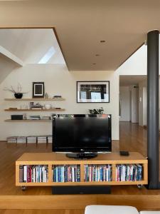 una sala de estar con TV en una mesa con DVD en Apartment Penthouse Festina Lente, en Sombor