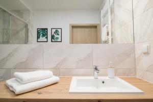 a white bathroom with a sink and a mirror at Apartamenty Dębowa 3 in Polanica-Zdrój