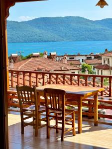 a wooden table and chairs on a balcony with a view at Koparan Apart Hotel in Akyaka