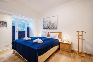 una camera da letto con un letto blu e asciugamani di FeWo Prora - Ostseebrise a Binz