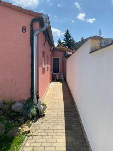 a brick alleyway leading to a pink building at Rodinný dom Auris in Piešťany