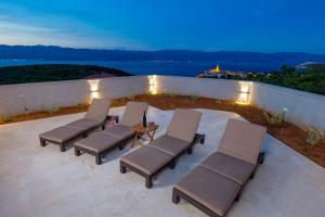 a group of chairs and a table on a patio at Villa Giulietta in Vrbnik
