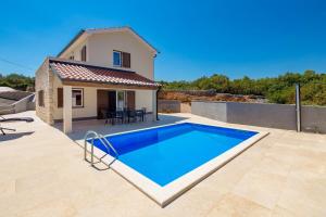 a villa with a swimming pool in front of a house at Villa Giulietta in Vrbnik