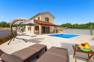 a backyard with a swimming pool and a house at Villa Maestral in Vrbnik