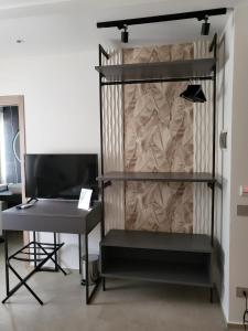 a room with a desk and a shelf with a computer at Alma Salina Suite in Margherita di Savoia