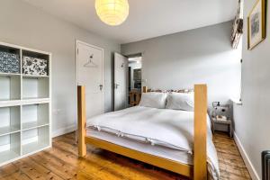 una camera da letto con un letto, pareti bianche e pavimenti in legno di Port Meadow View a Oxford