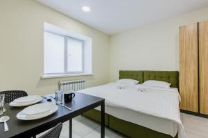 ein Schlafzimmer mit einem Bett und einem Tisch mit Tellern darauf in der Unterkunft GD Apartment osokorky in Kiew