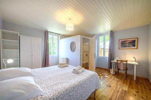 a bedroom with a bed and a table and windows at Lot & Garonne - Magnifique gîte de groupe avec piscine et vue panoramique en pleine campagne Proche Agen in Castelmoron-sur-Lot +22 photos