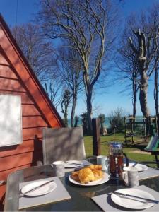 una mesa con un plato de comida encima en Escape to a Clifftop Chalet with pool and tennis onsite - 1A Kingsdown Holiday Park en Kingsdown