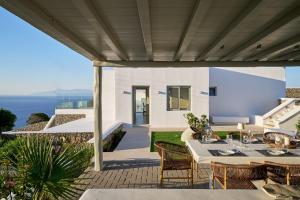 a patio with a table and chairs and the ocean at Villa j-view in Psarou