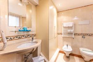 ein Badezimmer mit einem Waschbecken, einem WC und einem Spiegel in der Unterkunft Ca' Pinelli in Venedig