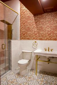 ein Bad mit einem WC, einem Waschbecken und einer Dusche in der Unterkunft Niagara Grandview Boutique Hotel in Niagara Falls