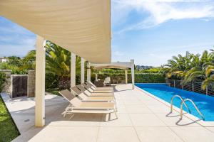 a group of lounge chairs on a patio next to a swimming pool at Villa Laura in Pula