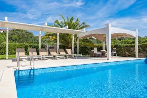 a swimming pool with chairs and a pavilion next to a swimming pool at Villa Laura in Pula
