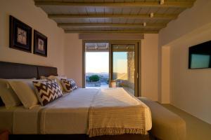 a bedroom with a large bed with a large window at Villa j-view in Psarou +36 photos
