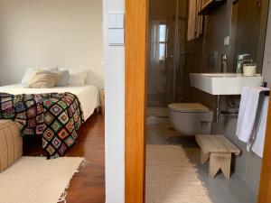 a bathroom with a bed and a sink and a toilet at Ferreira Borges Nomadic Ap A in Porto