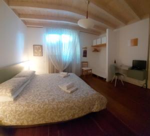 a bedroom with a large bed and a desk at Relais diVINO in Ala