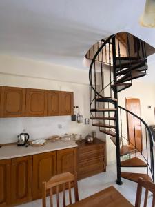 una escalera de caracol en una cocina con mesa y sillas en Loft Oasis en Chanioti