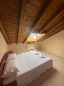 una camera da letto con un grande letto bianco e un soffitto in legno di Loft Oasis a Hanioti