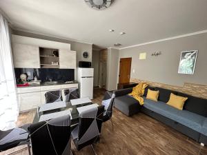 a living room with a blue couch and chairs at Dorina Wellness Apartman in Siófok