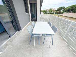 a white table and chairs on a balcony at LUX apartments STARS in Follonica