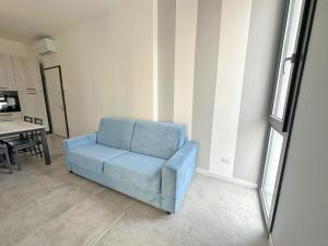 een blauwe stoel in een woonkamer met een tafel bij LUX apartments T in Follonica