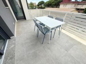 a white table and chairs on a balcony at LUX apartments STARS in Follonica +1 photo