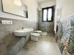 La salle de bains est pourvue d'un lavabo et de toilettes. dans l'établissement LUX apartments T, à Follonica