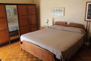 a bedroom with a bed and a dresser and a mirror at L'appartamento della Stazione di Saronno in Saronno