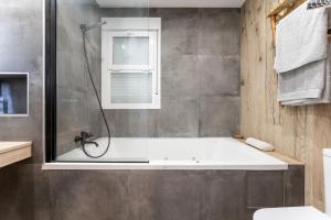 a bathroom with a bath tub and a shower at MalagaSuite Huelin Urban Estudio in Málaga