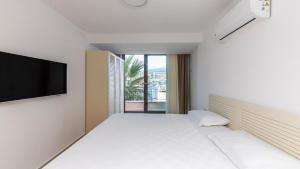 a bedroom with a bed and a flat screen tv at Villa House Sea View Türkbükü in Bodrum City