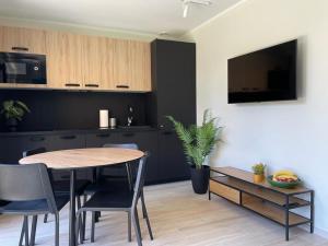 a kitchen and dining room with a table and chairs at Apartamenty przy Parku -150m od plaży in Darłówko