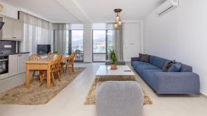 a living room with a blue couch and a table at Villa House Sea View Türkbükü in Bodrum City