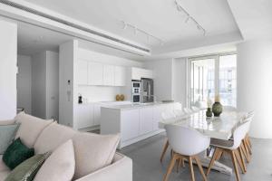 a white kitchen and living room with a table and chairs at Exclusive Meier on Rothschild by Five Stay in Tel Aviv