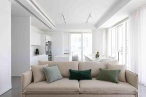 a living room with a couch with four pillows at Exclusive Meier on Rothschild by Five Stay in Tel Aviv