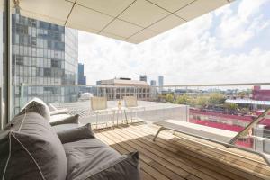 balcón con sofá y vistas a la ciudad en Exclusive Meier on Rothschild by Five Stay en Tel Aviv