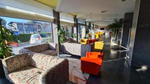 a room with couches and chairs in a building at Aqua Hotel in Varna City +38 photos