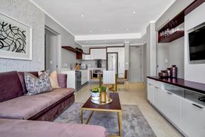 ein Wohnzimmer mit einem Sofa und einem Tisch in der Unterkunft Executive 3 bed apartment with balcony & Executive 2 bed apartment in Sandton in Johannesburg