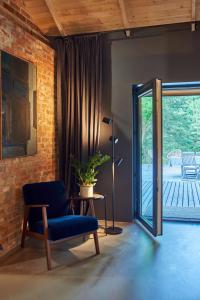 a living room with a blue chair and a patio at Villa Kamionka in Kamionka