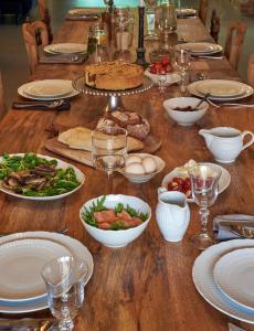 a long wooden table with plates and bowls of food at Villa Kamionka in Kamionka