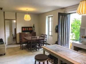 a kitchen and dining room with a table and chairs at Le Mas du figuier, Maison de vacances in Le Bousquet-dʼOrb +11 photos