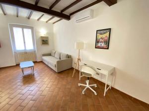 a living room with a couch and a desk at BnBetter - Apartment Teddy, near the Train Station to Florence in Prato +29 photos
