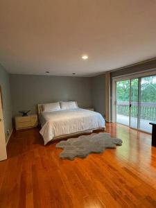 Schlafzimmer mit einem Bett und Holzboden in der Unterkunft Beautiful House in Livingston (20 miles from NYC) in Livingston