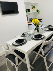 a white dining room table with chairs and a tv at Luxury home in Anfield in Liverpool