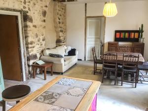 a living room with a couch and a table at Le Mas du figuier, Maison de vacances in Le Bousquet-dʼOrb