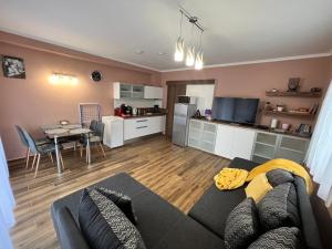 sala de estar con sofá, mesa y cocina en Dorina Wellness Apartman, en Siófok