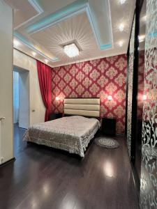 a bedroom with a bed and a red wall at Lovely Apartment in Old Tbilisi in Tbilisi City