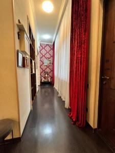 a long corridor with red curtains and a hallway with at Lovely Apartment in Old Tbilisi in Tbilisi City