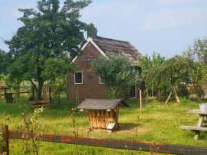an old house with a dog house in the yard at Trekkershut - Tiny House - Hikers cottage in Wijster