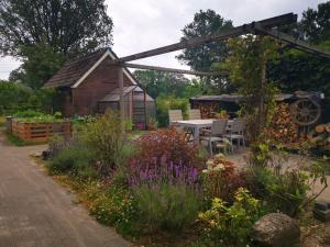 un jardin avec une table et des chaises et un bâtiment dans l'établissement Trekkershut - Tiny House - Hikers cottage, à Wijster